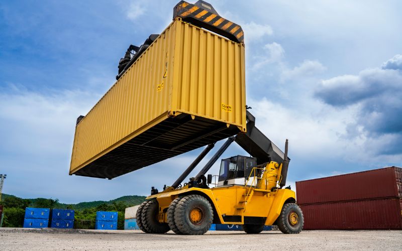 A bulldozer is unloading a container that has just arrived from the USA