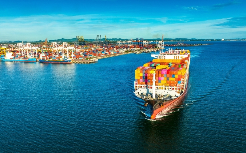 A large container ship moored at a port, symbolizing global shipping and commerce activities.