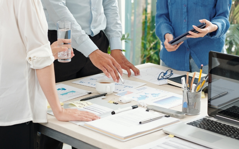 Business professionals collaborating at a desk, focused on understanding Treas. Reg. §1.994-1 and offsetting entries.