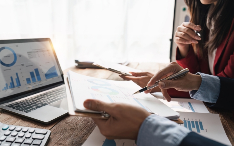 Group of business individuals working together on a laptop, discussing tax incentives and compliance for exporters.
