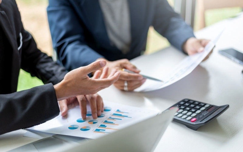 Financial advisors comparing producer’s loan flexibility with traditional bank financing