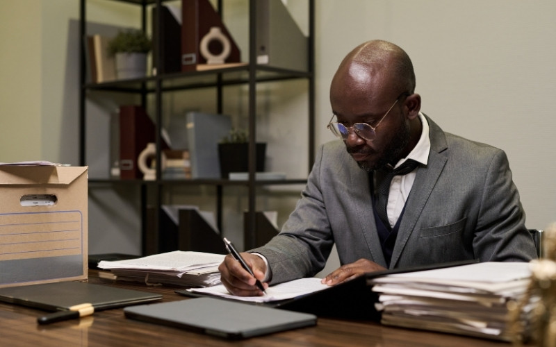 Tax professional reviewing and signing written producer loan obligation documents