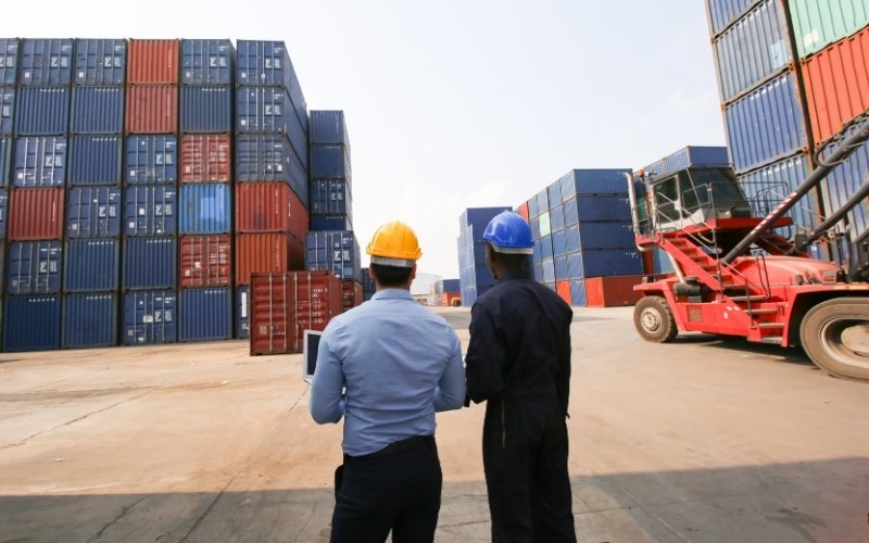 Export logistics professionals reviewing container operations for IC-DISC year-end compliance.